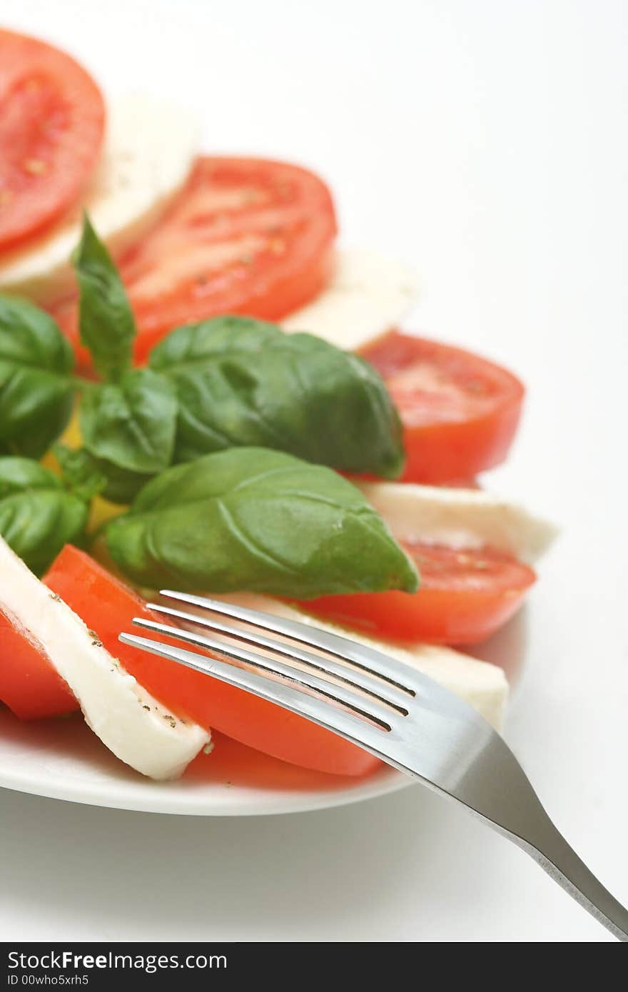 Close up of mozzarella tricolore salad with tomatoes and basil with drizzling of olive oil. Close up of mozzarella tricolore salad with tomatoes and basil with drizzling of olive oil.