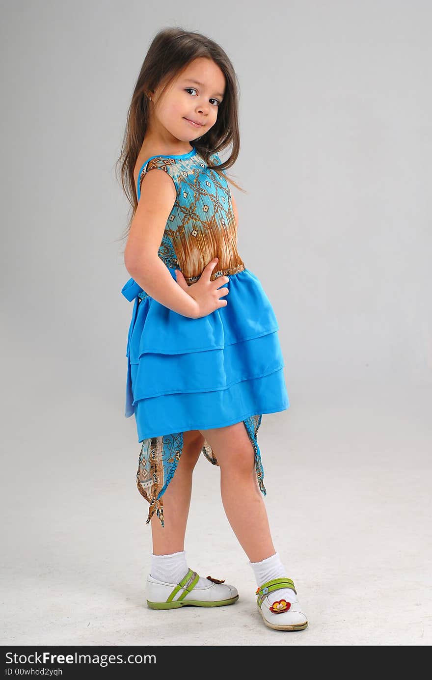 Little cute girl posing in a fancy blue dress. Little cute girl posing in a fancy blue dress