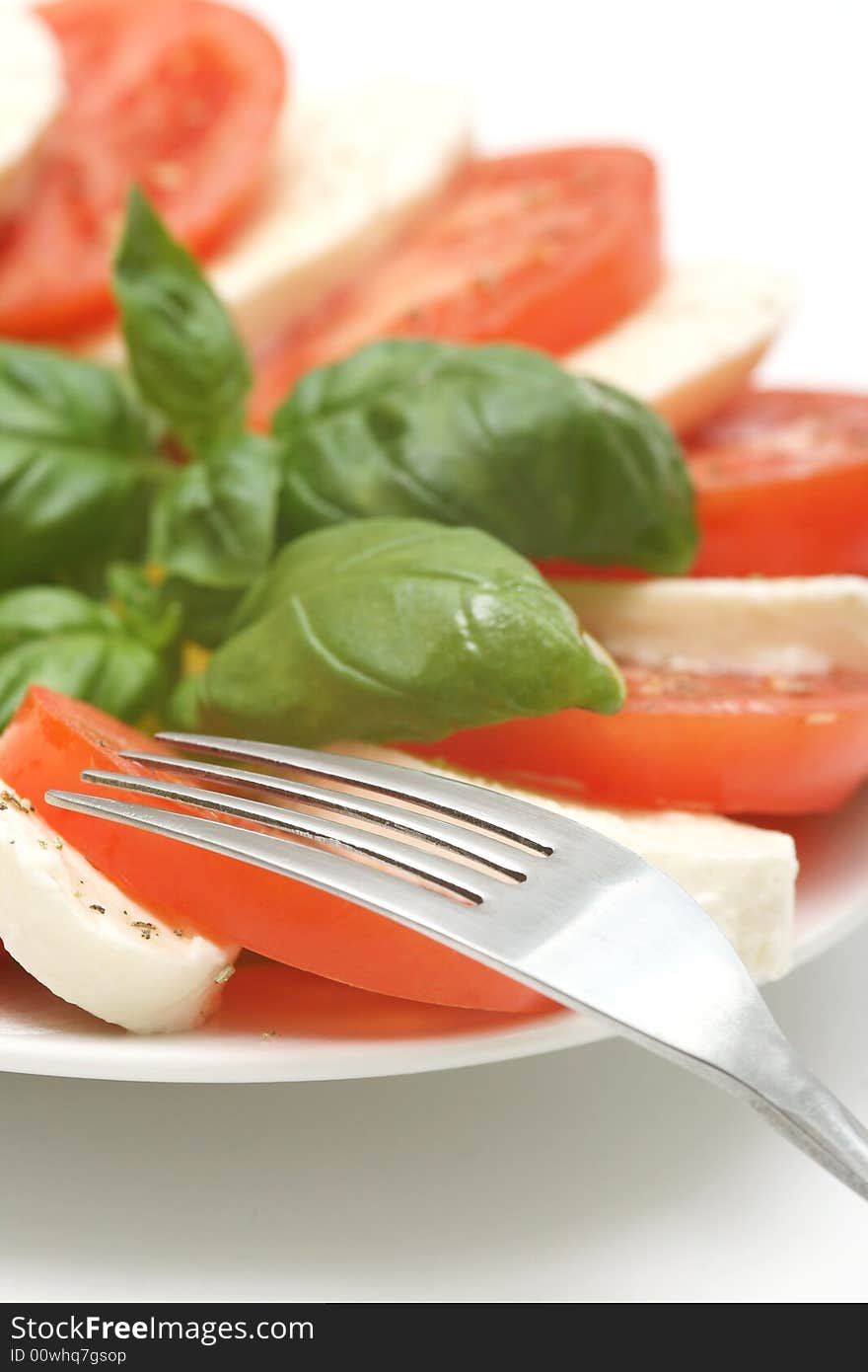 Close up of mozzarella tricolore salad with tomatoes and basil with drizzling of olive oil. Close up of mozzarella tricolore salad with tomatoes and basil with drizzling of olive oil.