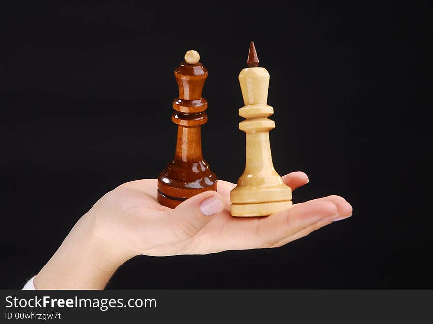 Two hands with black and white chesspieces. Two hands with black and white chesspieces