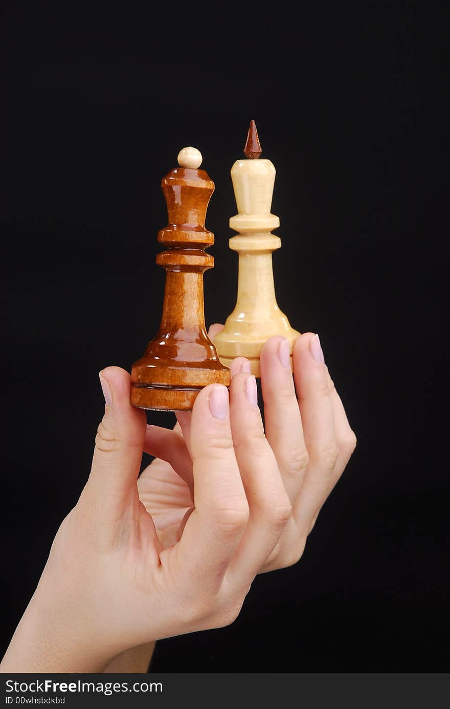 Two hands with black and white chesspieces. Two hands with black and white chesspieces