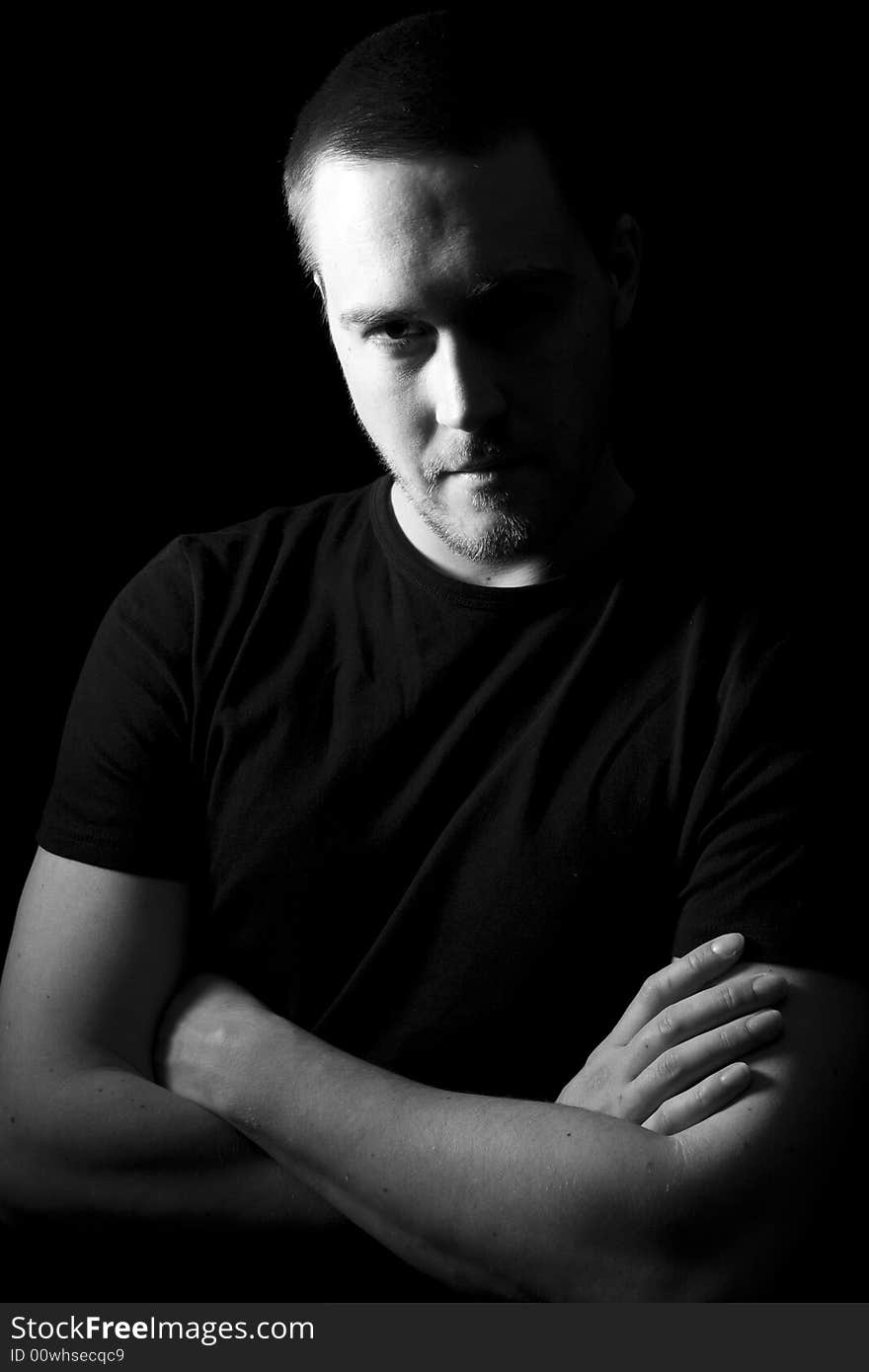 Portrait of a handsome young man in black and white (black background)