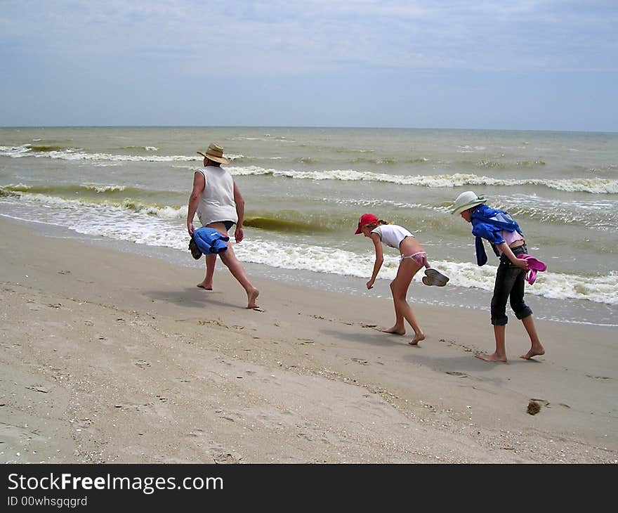 The father unhurriedly by wide step goes in front along the coast of sea, and two girls try to go on his tracks. The father unhurriedly by wide step goes in front along the coast of sea, and two girls try to go on his tracks.