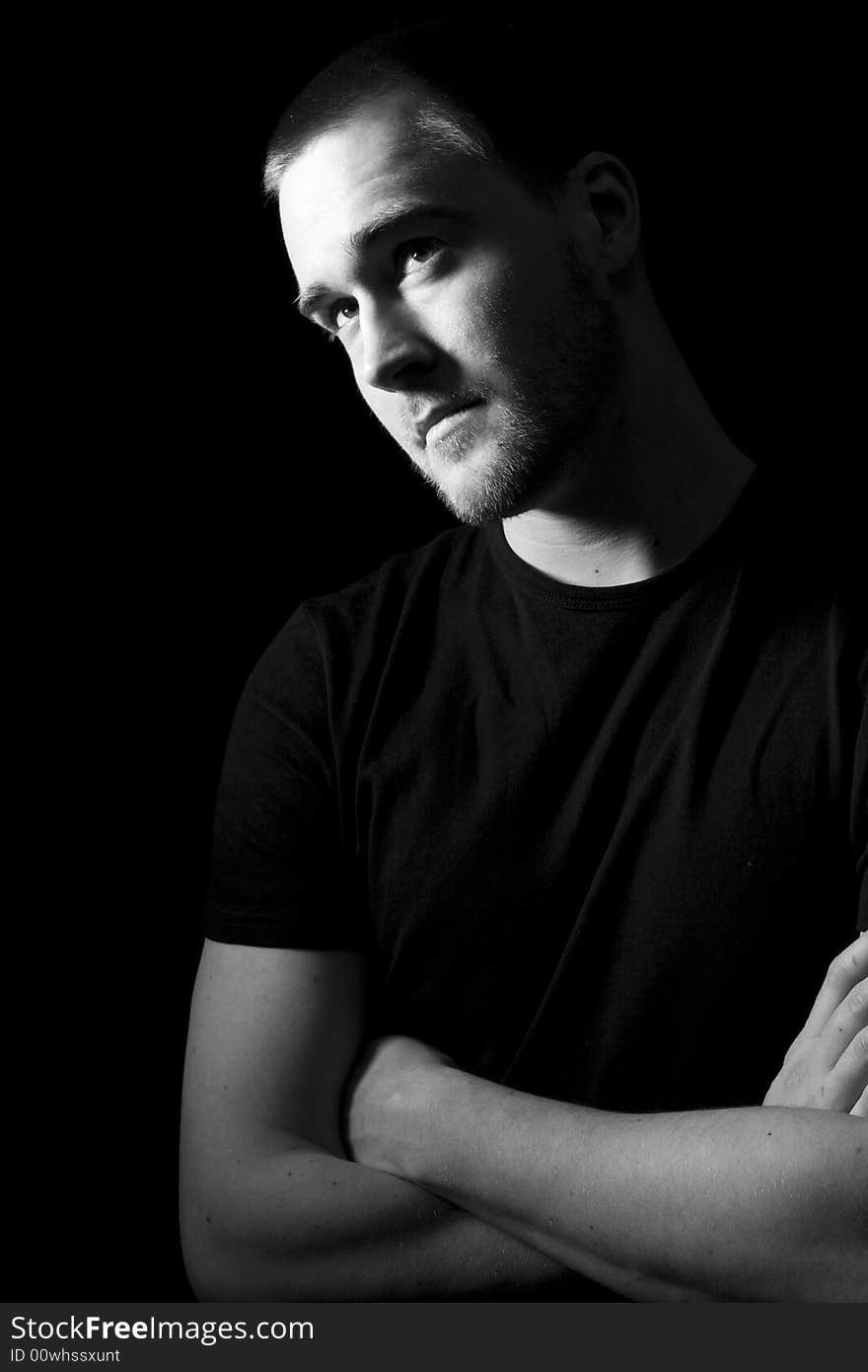 Portrait of a handsome young man in black and white (black background)