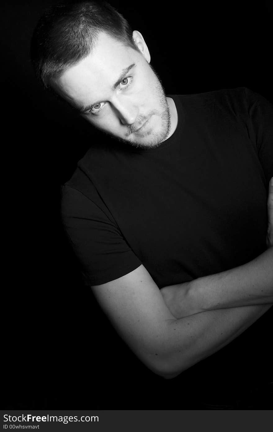 Portrait of a handsome young man in black and white (black background)