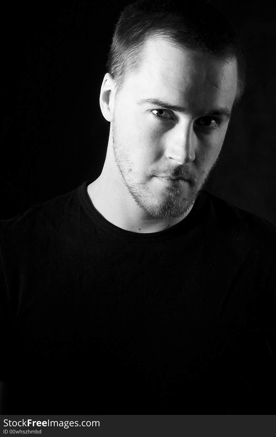 Portrait of a handsome young man in black and white (black background)