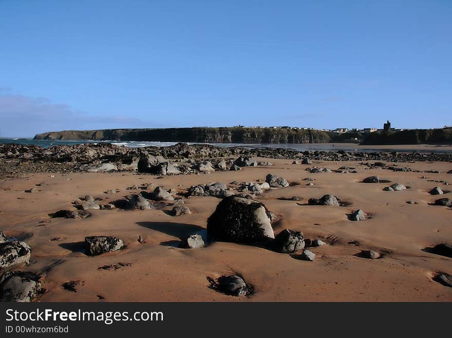 A rocky beach on the west of ireland with ballybunion castle in the background. A rocky beach on the west of ireland with ballybunion castle in the background