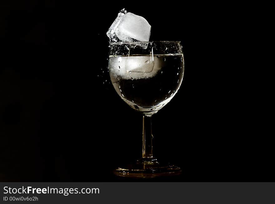 Ice cube falling on the edge of a glass. Ice cube falling on the edge of a glass