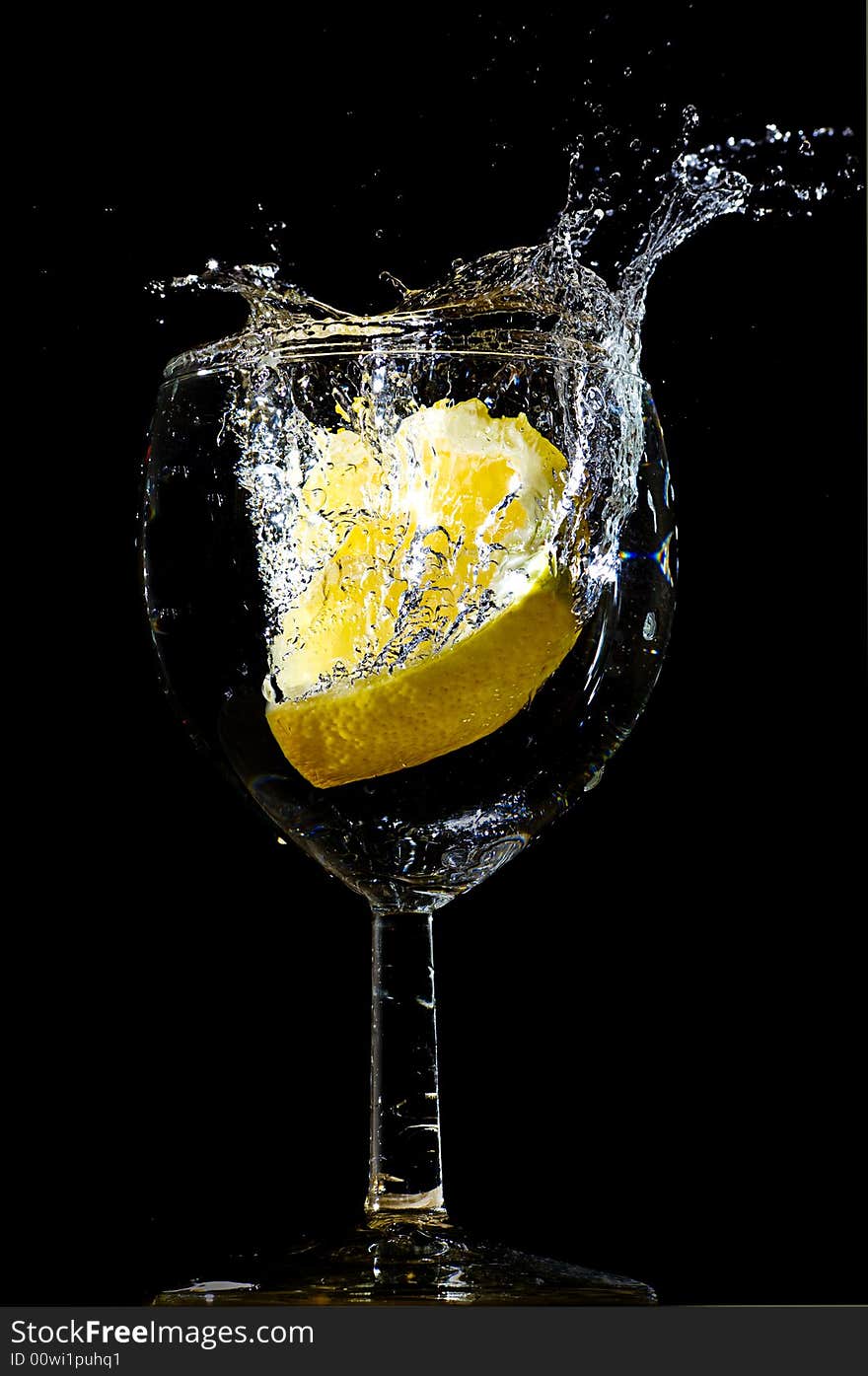 Piece of lemon falling in a glass making a big splash. Piece of lemon falling in a glass making a big splash