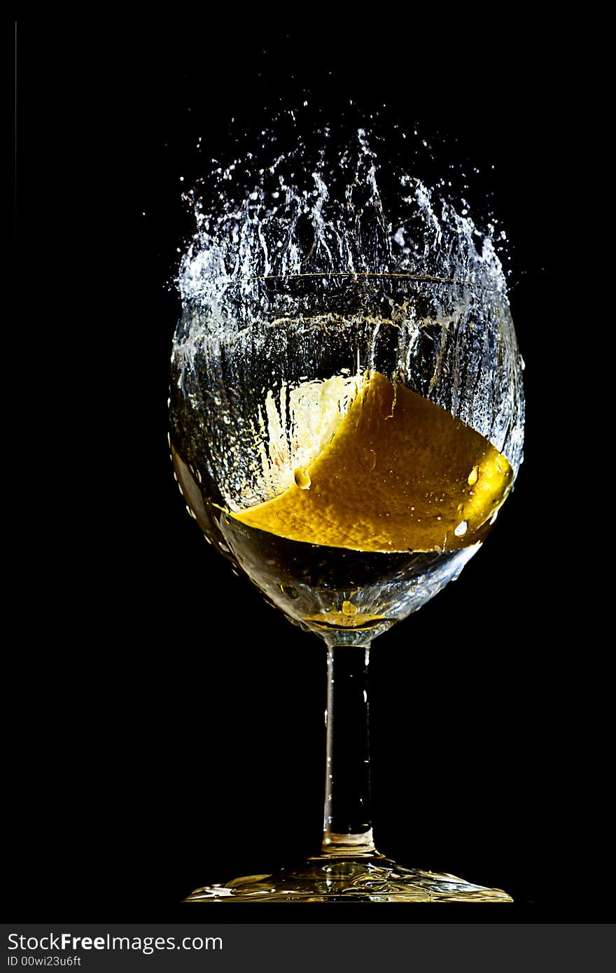 Piece of lemon falling in a glass making a big splash. Piece of lemon falling in a glass making a big splash