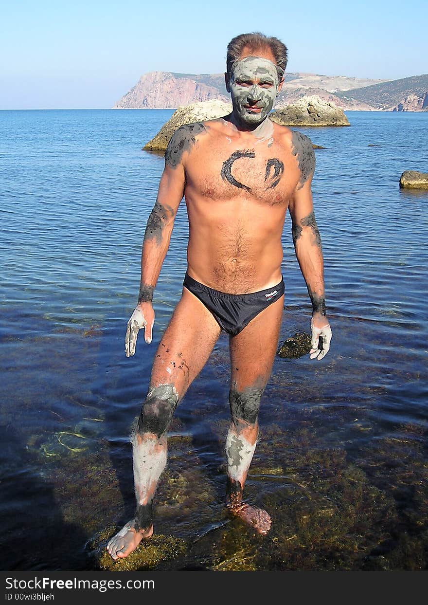 Man was smeared by useful therapeutic mud on the shore of Azov sea in order to obtain therapeutic effect. Mud gradually dries in the sun, and it then washes off by water. Man was smeared by useful therapeutic mud on the shore of Azov sea in order to obtain therapeutic effect. Mud gradually dries in the sun, and it then washes off by water.