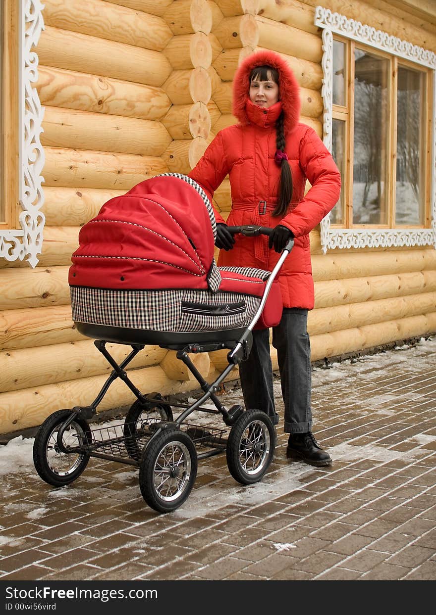 Winter Girl in Red Hood with Baby Carriage Outdoors