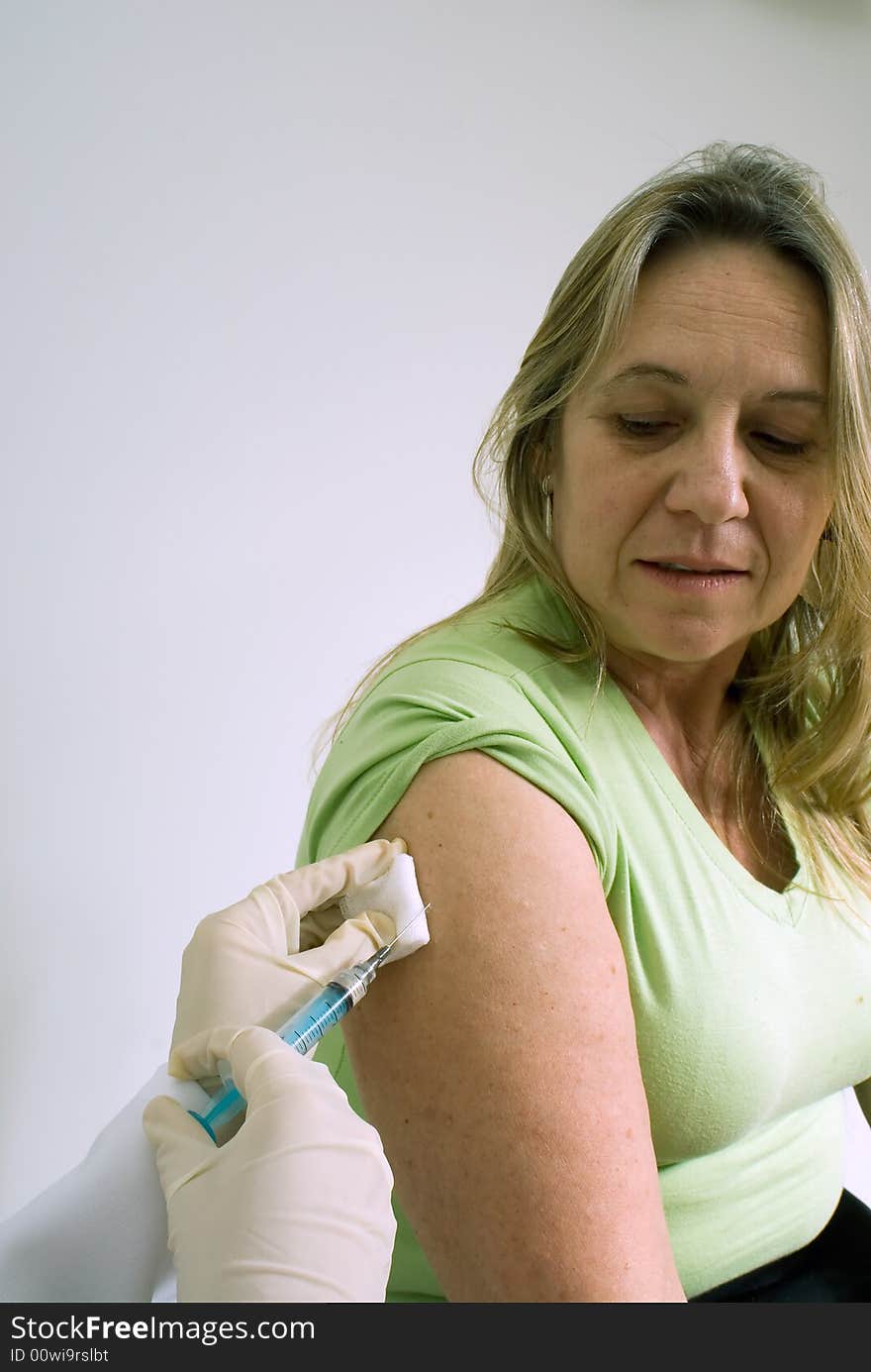 An isolated shot of a doctor/nurse about to give a female patient a shot in the arm. An isolated shot of a doctor/nurse about to give a female patient a shot in the arm.