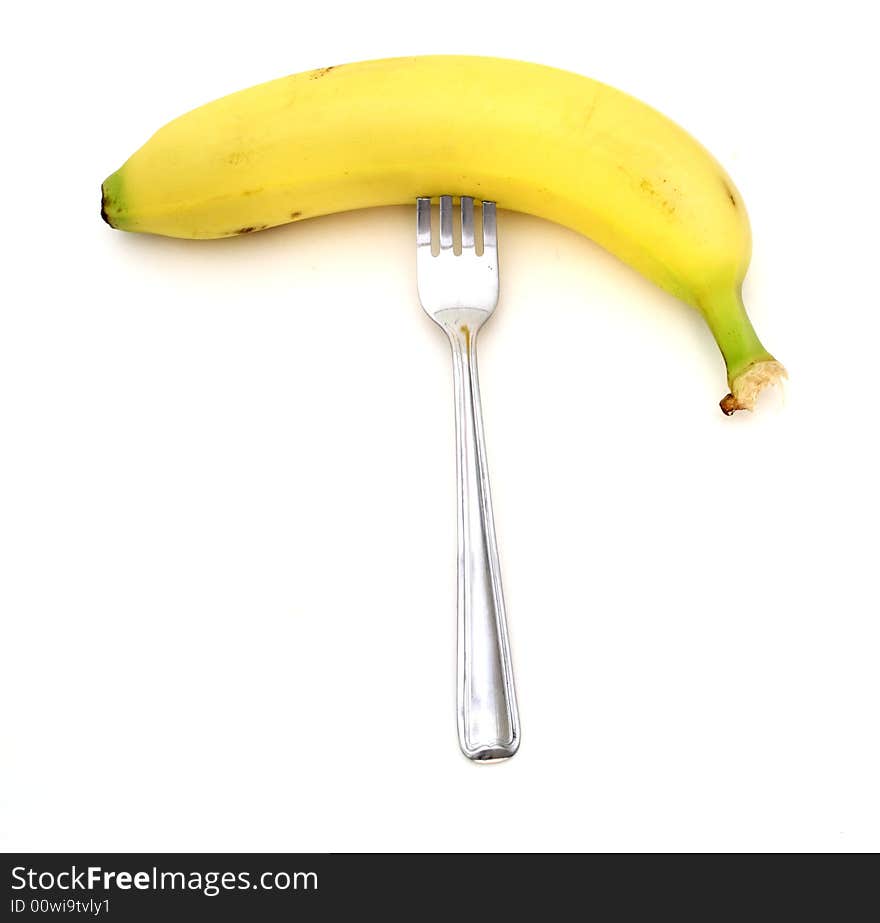 Ripe banana with a silver fork stick on it. Ripe banana with a silver fork stick on it