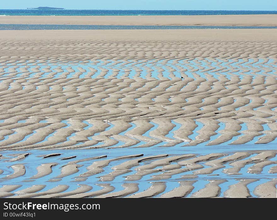 This shows a deeply sculptured beach at Hunter Creek. Water fills the low points to create an intricate pattern across the sand flats at low tide. This shows a deeply sculptured beach at Hunter Creek. Water fills the low points to create an intricate pattern across the sand flats at low tide.