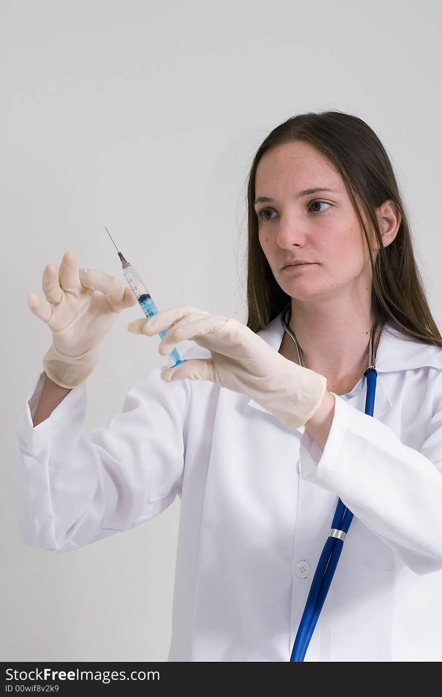 An isolated shot of a doctor/nurse preparing an injection/shot. An isolated shot of a doctor/nurse preparing an injection/shot.