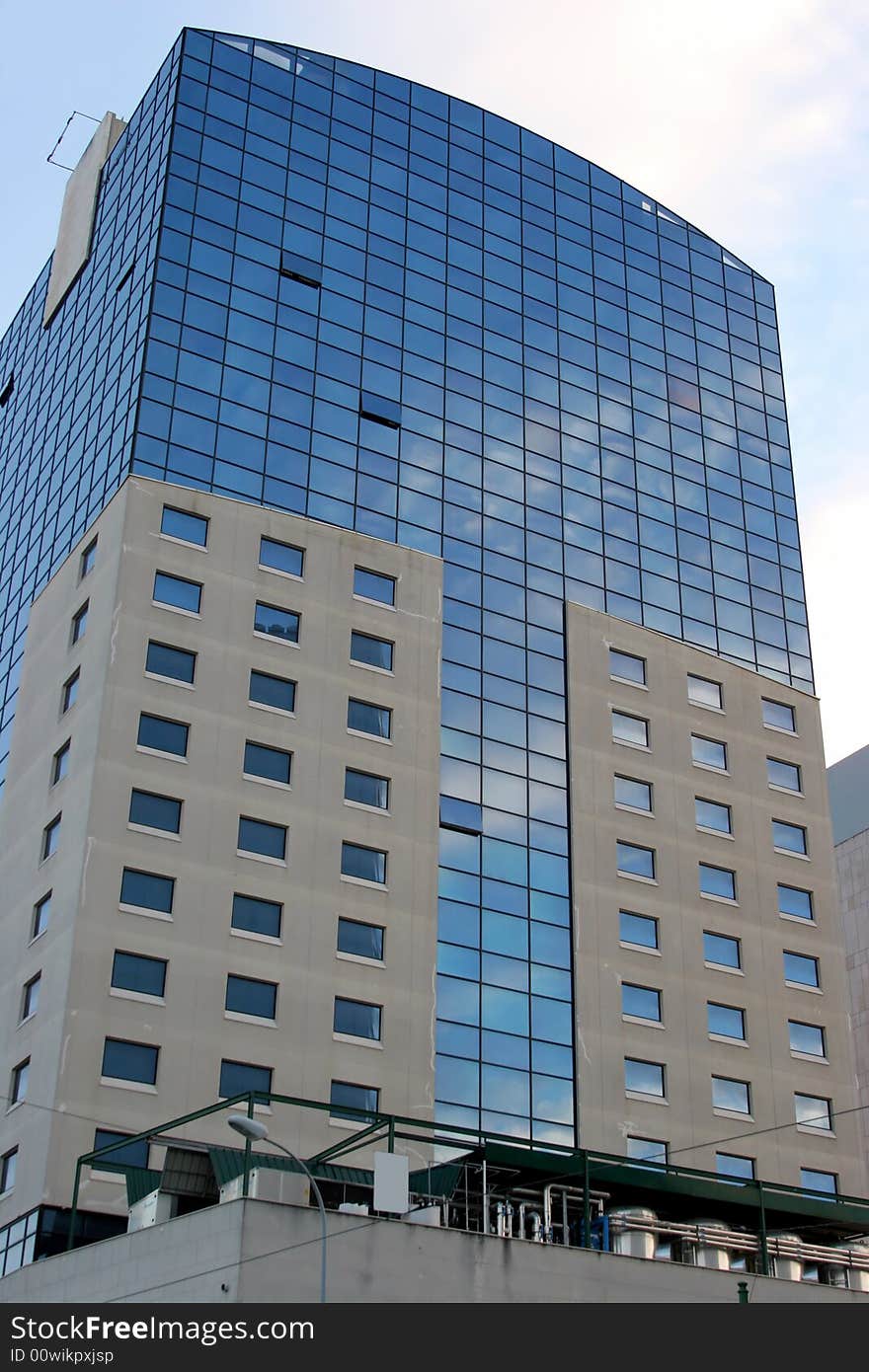 Glass building against a bright blue sky with cloud reflections. Glass building against a bright blue sky with cloud reflections