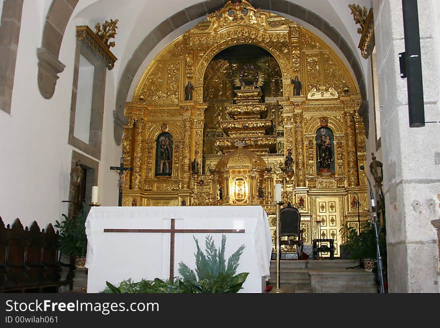 Portuguese church main altar with golden decoration behind