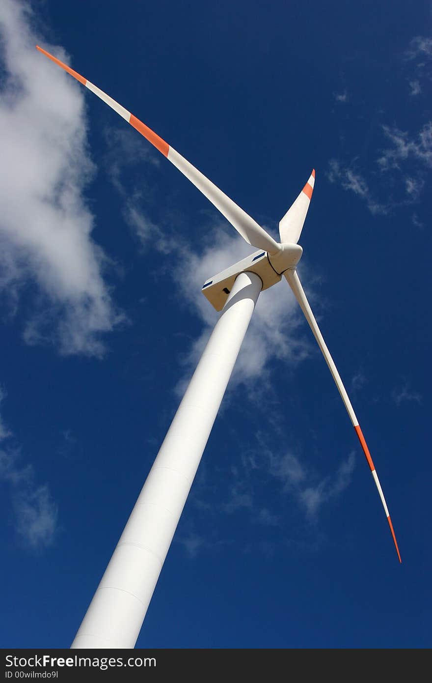 Wind mill power generator in a deep blue sky