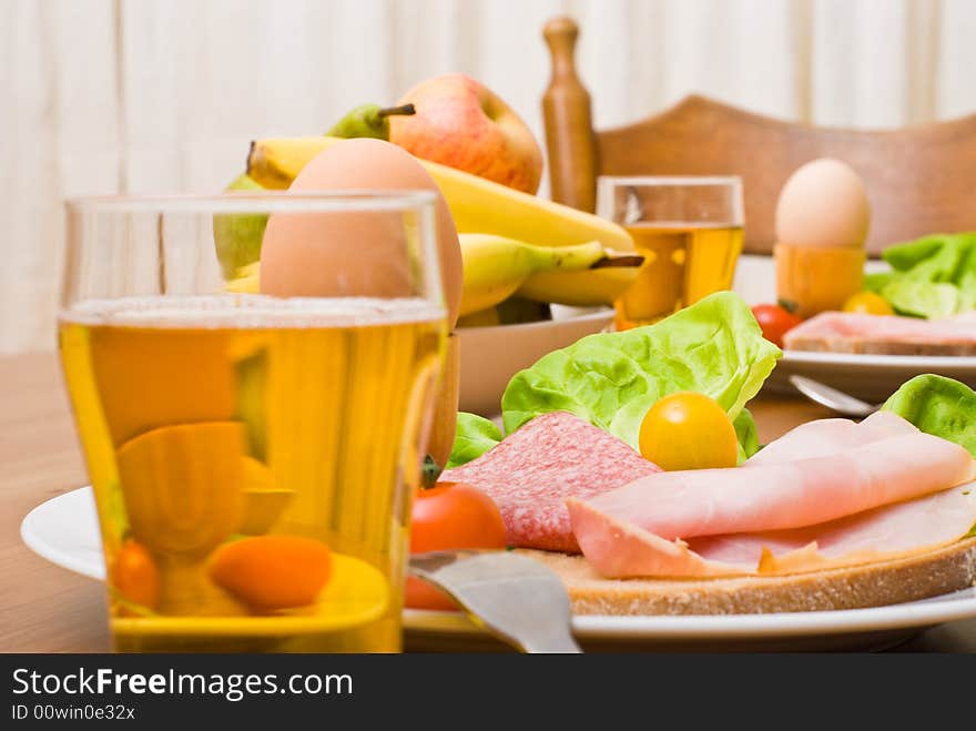 Table served with snacks. Fruits, vegetables, bread, egg, ham etc. Table served with snacks. Fruits, vegetables, bread, egg, ham etc.