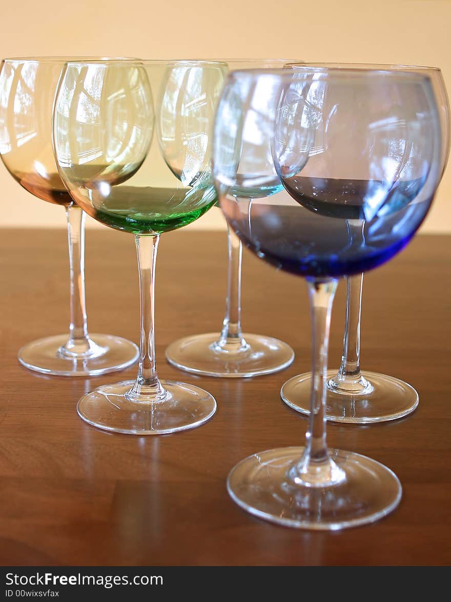 Different colored wine glasses with a simple background