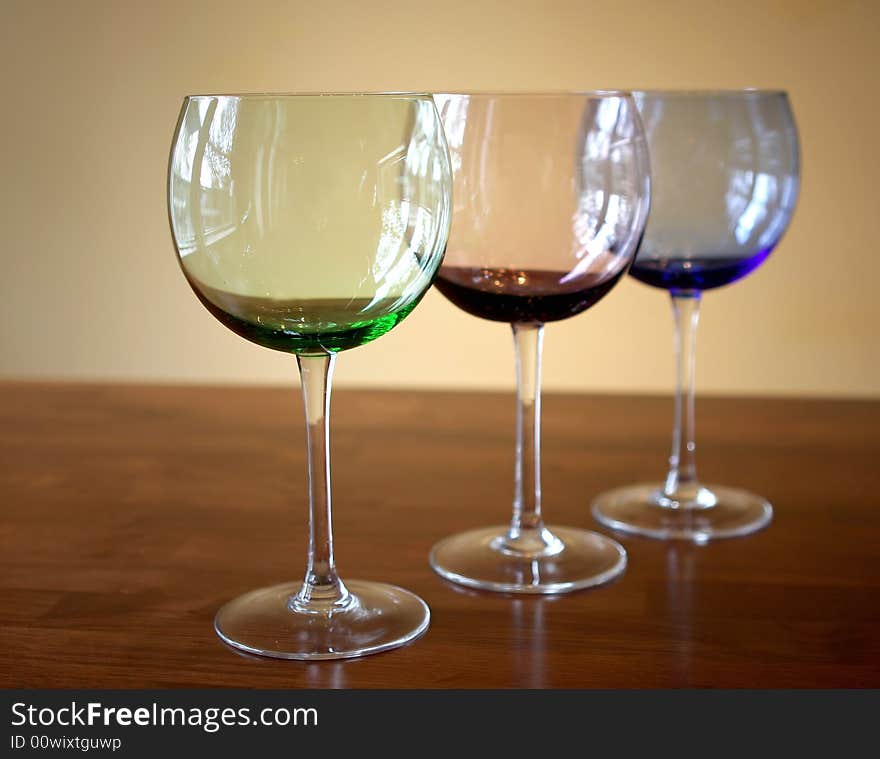 Different colored wine glasses with a simple background