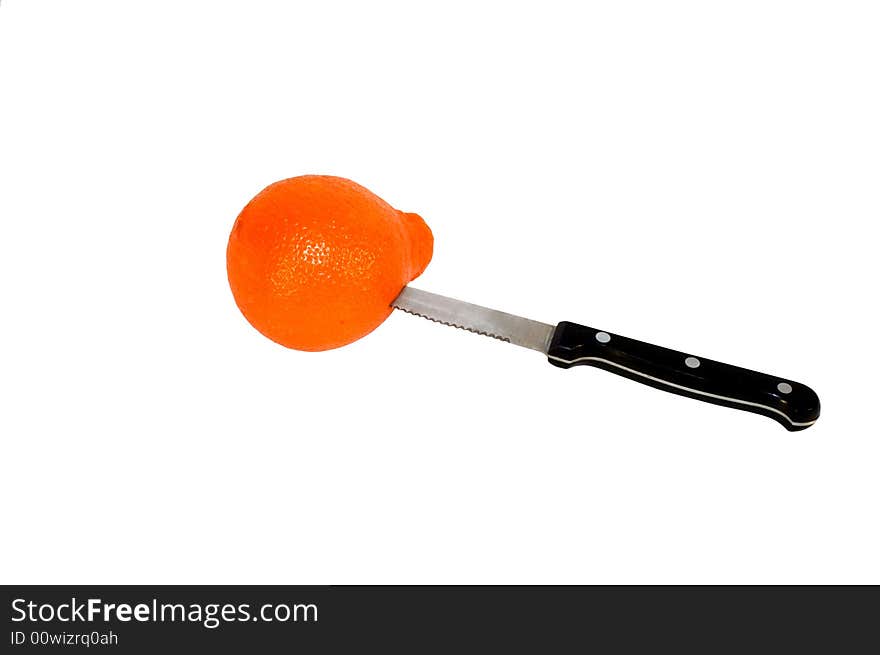 Serrated knife stuck into orange fruit peel. Serrated knife stuck into orange fruit peel