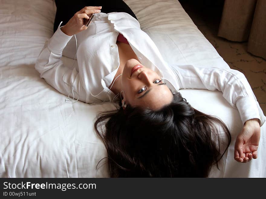 Woman listening music on the bed. Woman listening music on the bed