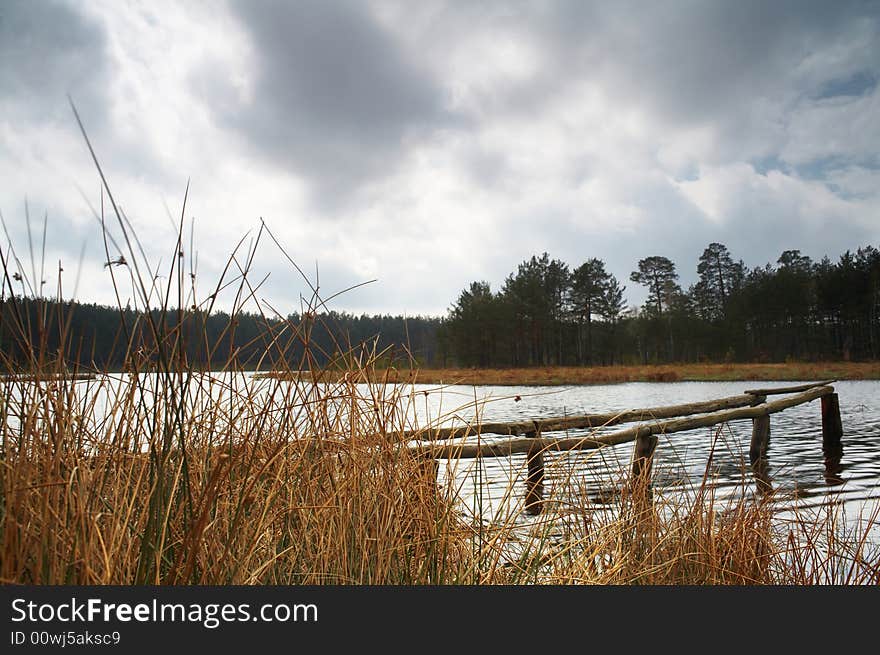 A lake in forest and dramatic sky