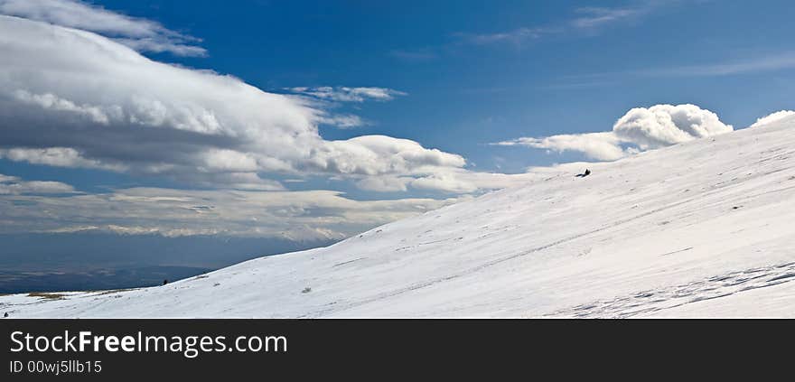 Snowy white mountain slope with blue sky panorama. Snowy white mountain slope with blue sky panorama