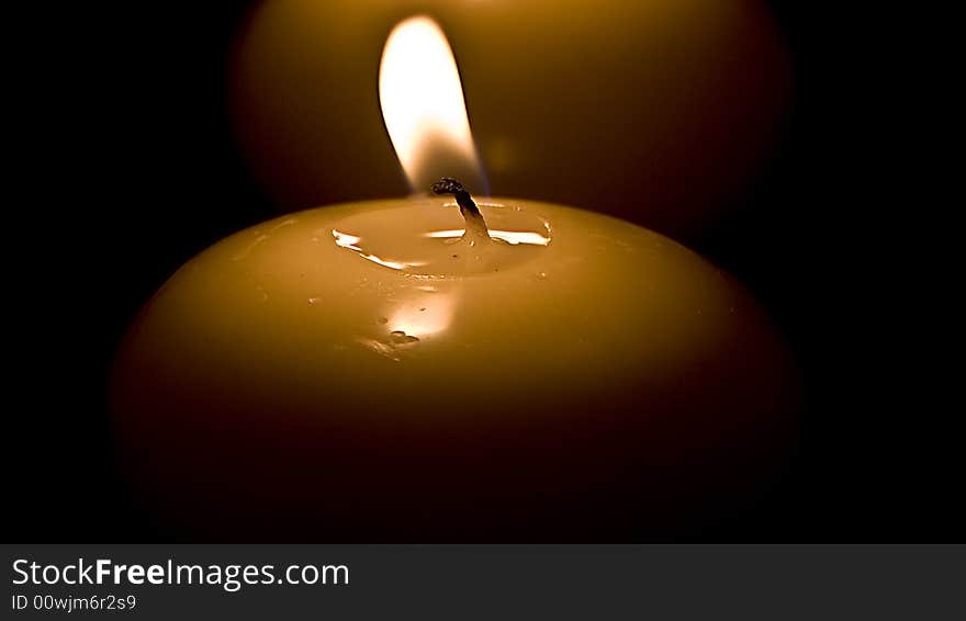 Four candles in a row on a black background.