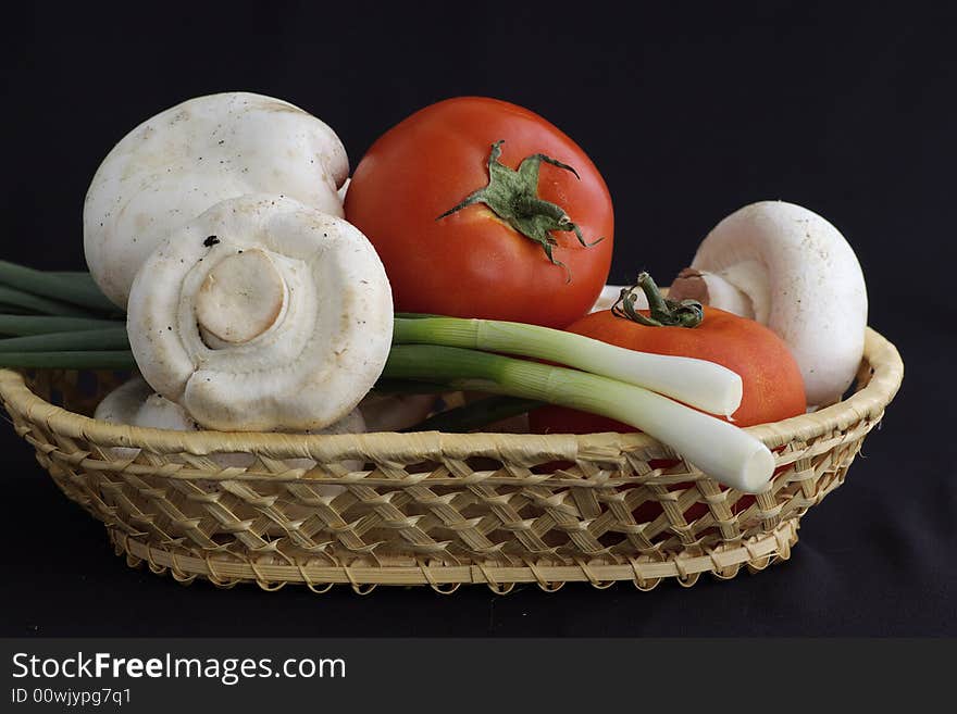 Several agarics, tomatoes and onion against the black background by the closeup. Several agarics, tomatoes and onion against the black background by the closeup