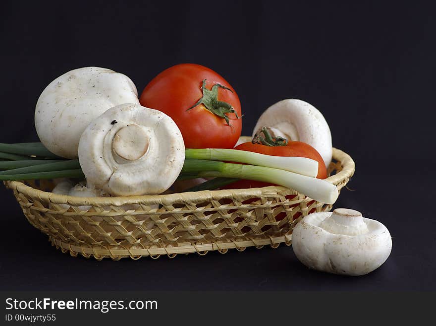 Several agarics, tomatoes and onion against the black background by the closeup. Several agarics, tomatoes and onion against the black background by the closeup