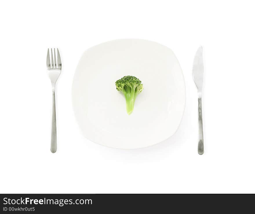 Broccoli on a dinner plate with fork and knife