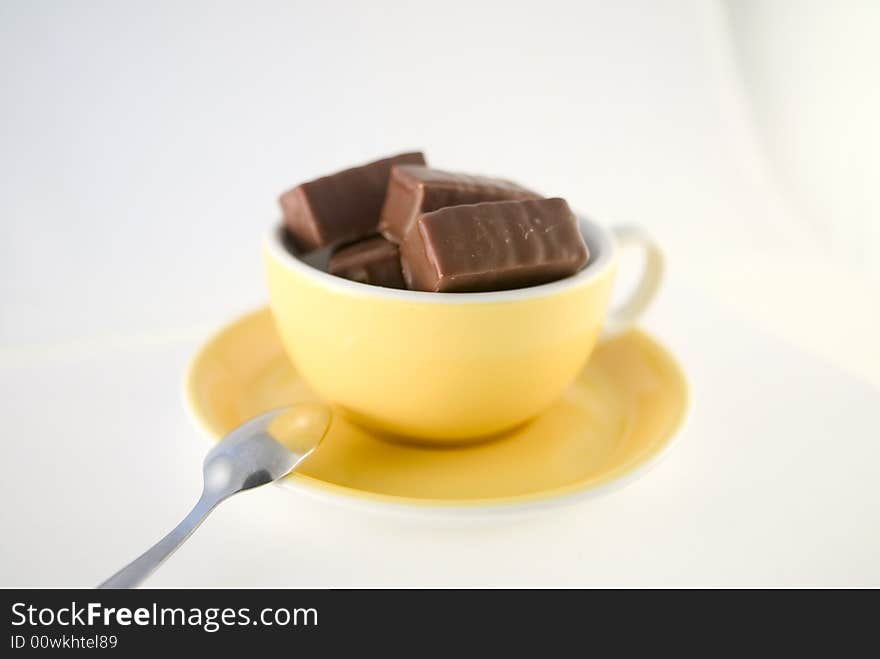 Sweet, tasty chocolate bars in nice yellow cup, metaphor of hot chocolate. Sweet, tasty chocolate bars in nice yellow cup, metaphor of hot chocolate