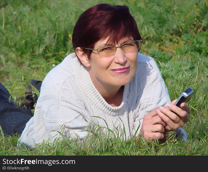 A woman rests on a grass.