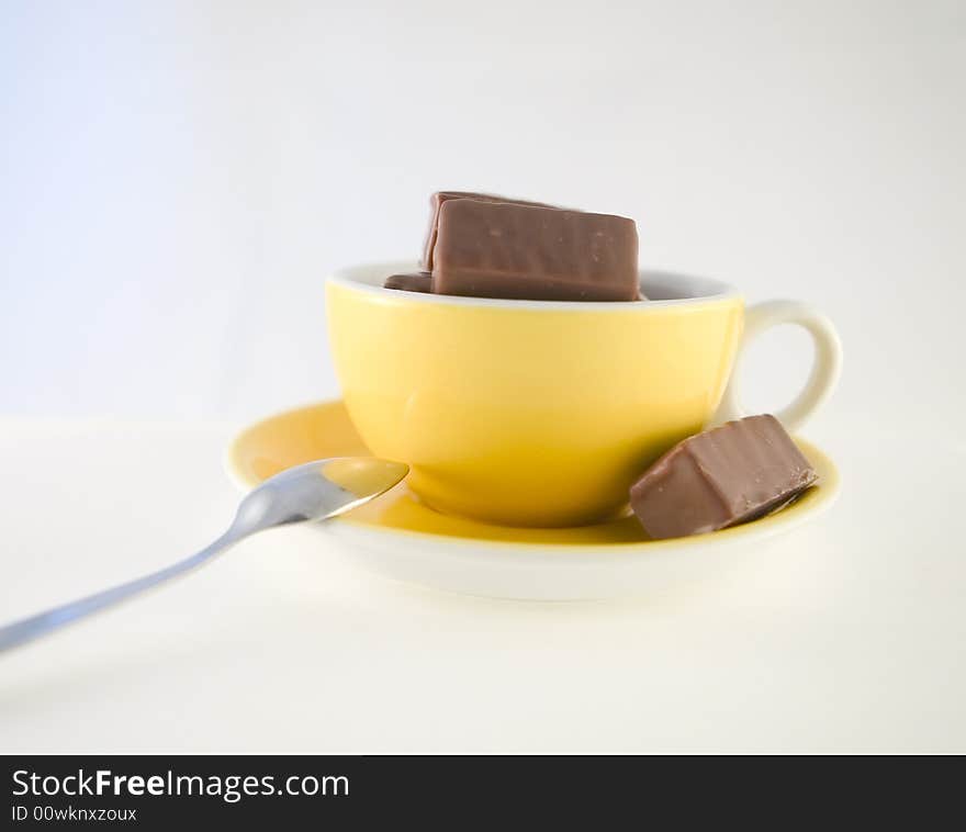 Chocolade candies in yellow cup, hot chocolate