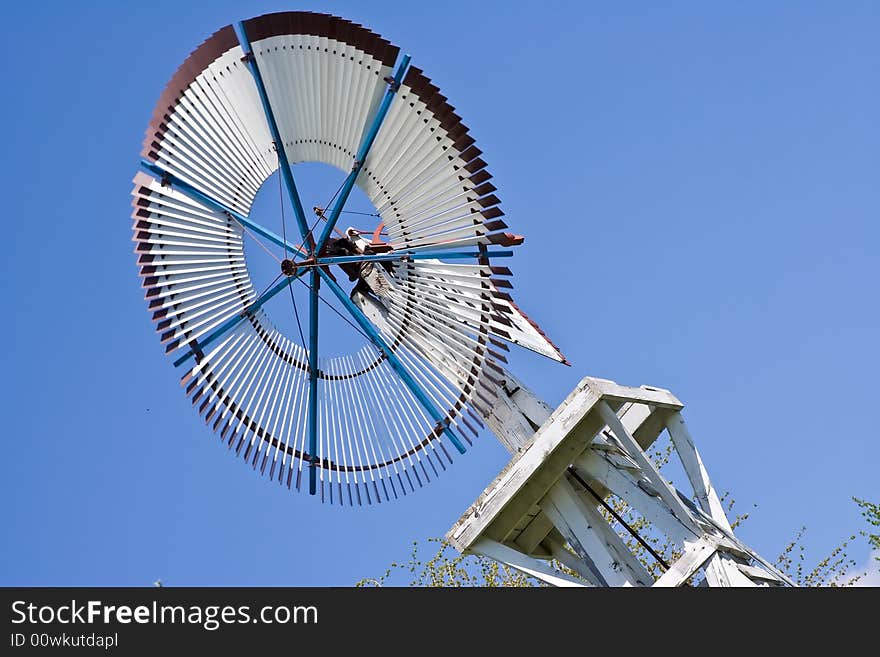 Old windmill against a blue sky nice green background image. Old windmill against a blue sky nice green background image