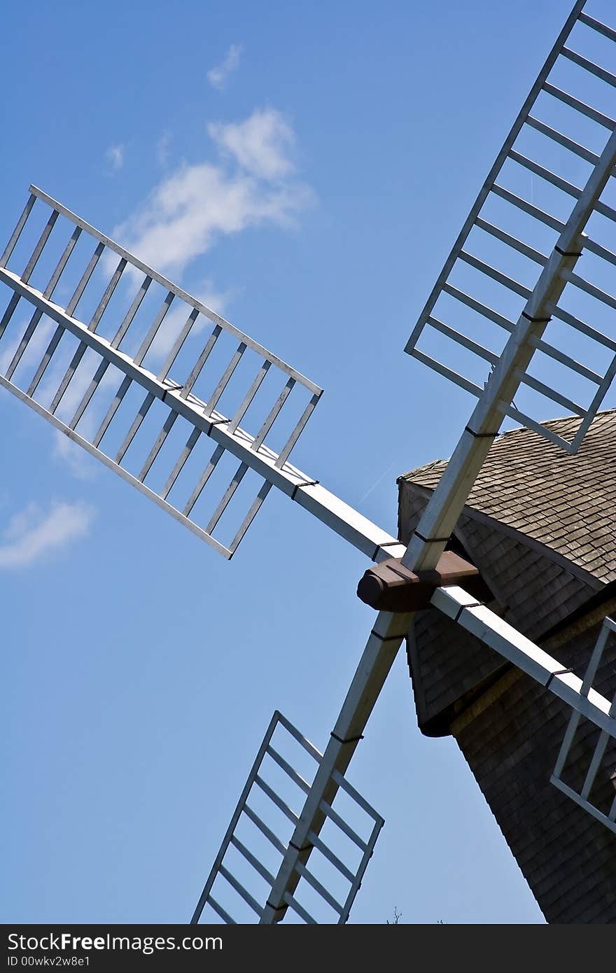 Old windmill against a blue sky nice green background image. Old windmill against a blue sky nice green background image