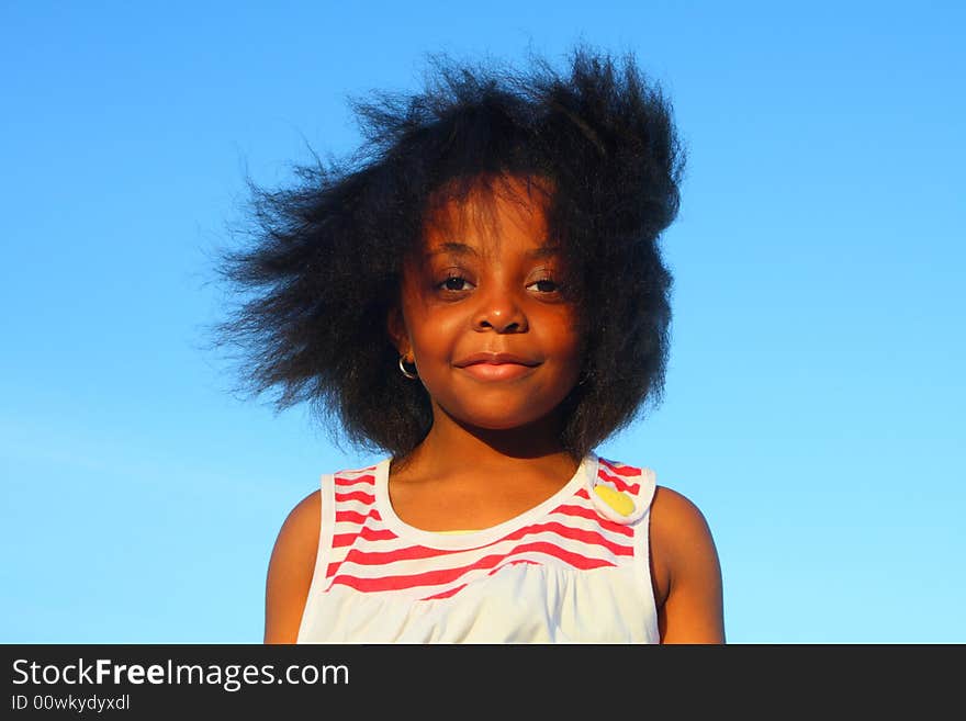 Beautiful young girl smiling with blue sky background. Beautiful young girl smiling with blue sky background