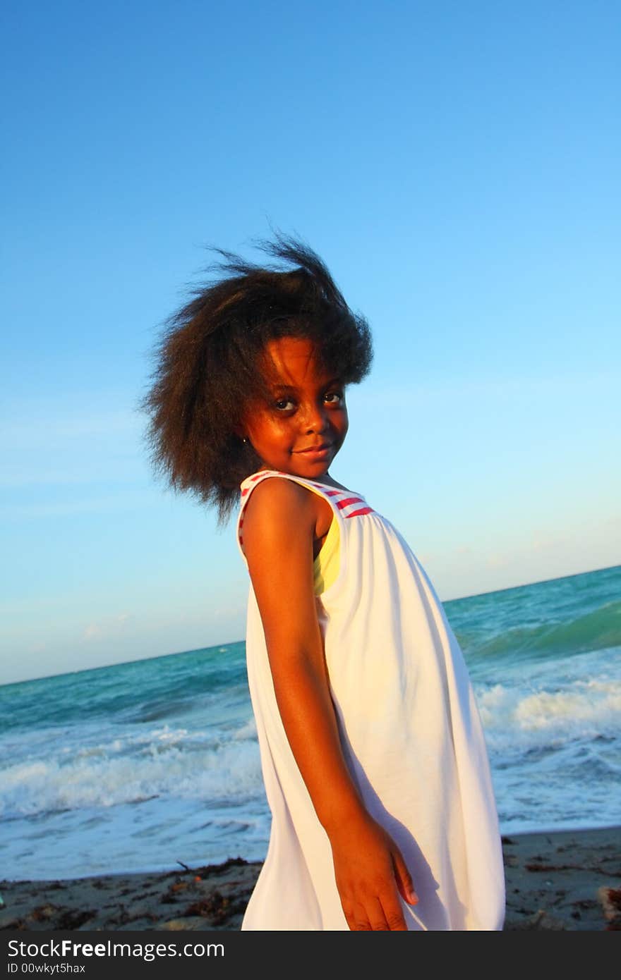 Young Black Child on the beach smiling and watching the sunset. Young Black Child on the beach smiling and watching the sunset.