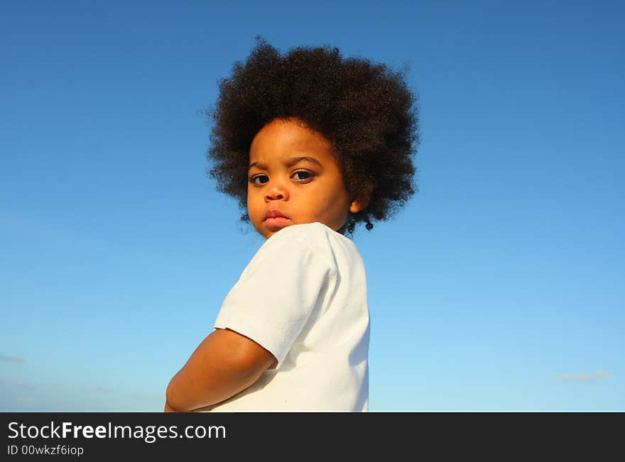 Cute little child with a blue sky background. Cute little child with a blue sky background.