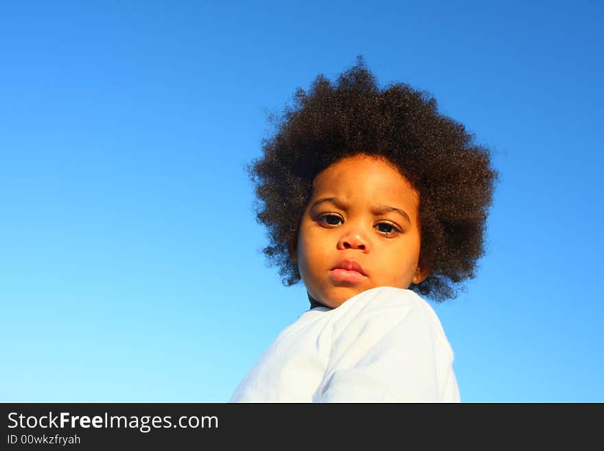 Cute little child with a blue sky background. Cute little child with a blue sky background.