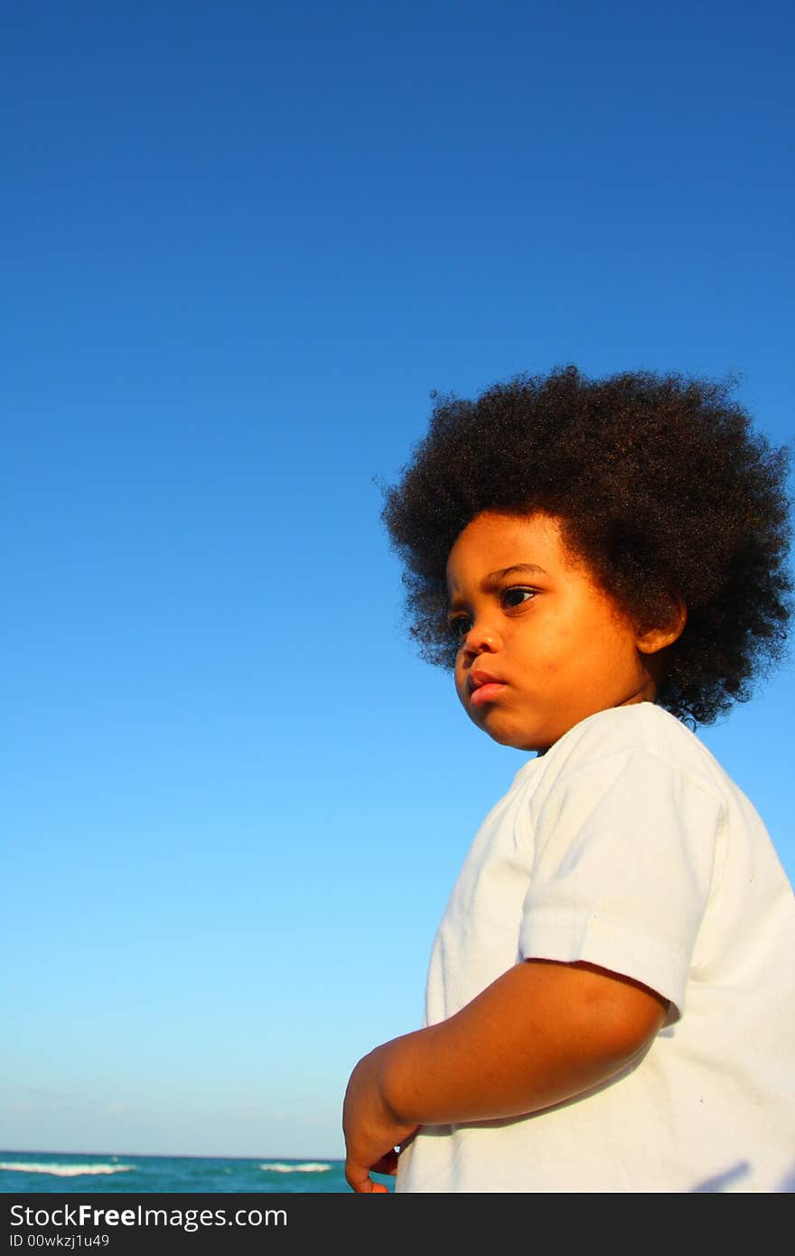 Young child at the beach with a blue sky background which could be used for copyspace. Young child at the beach with a blue sky background which could be used for copyspace.