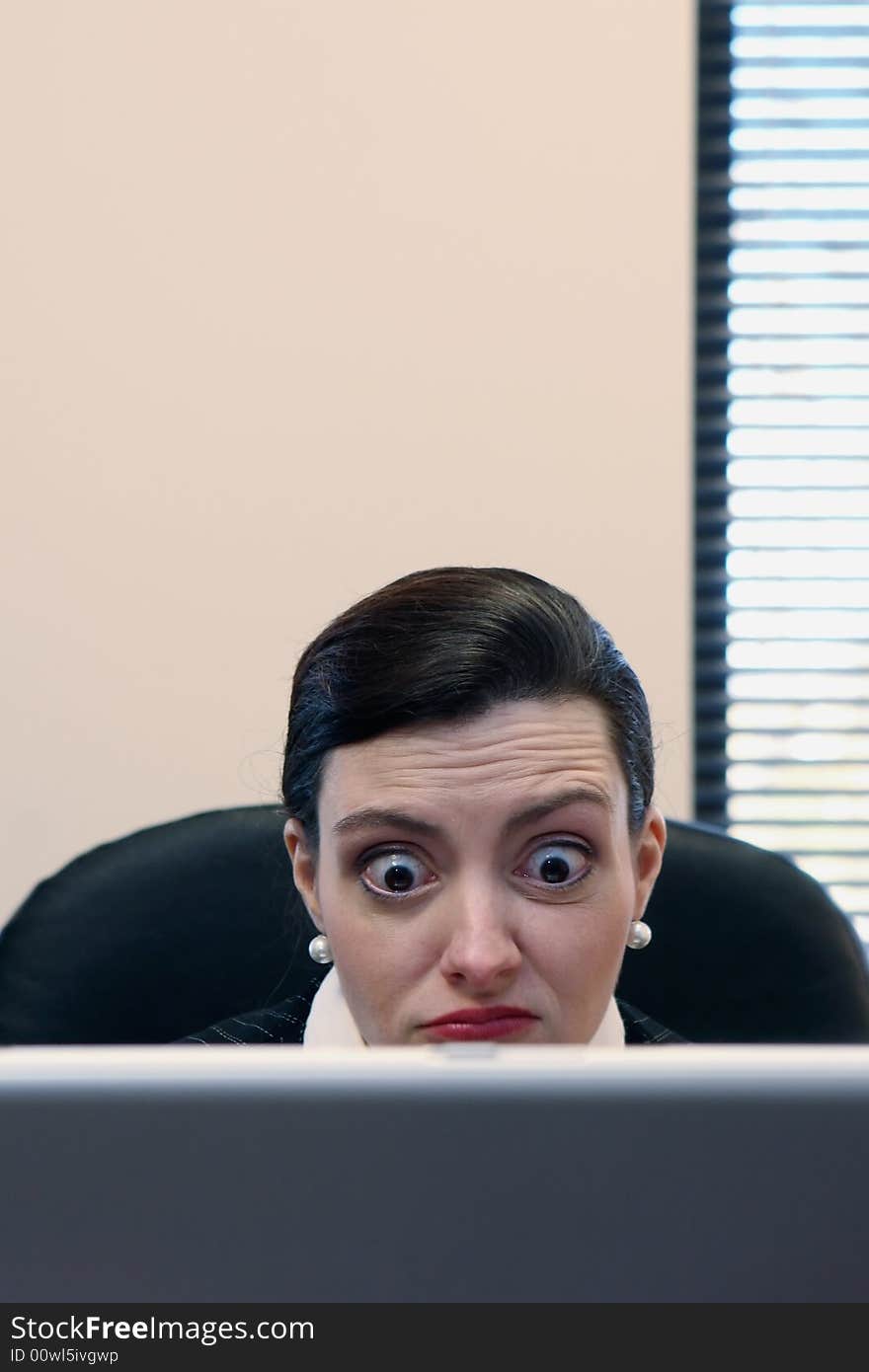 Businesswoman sitting at her desk behind her laptop. Businesswoman sitting at her desk behind her laptop