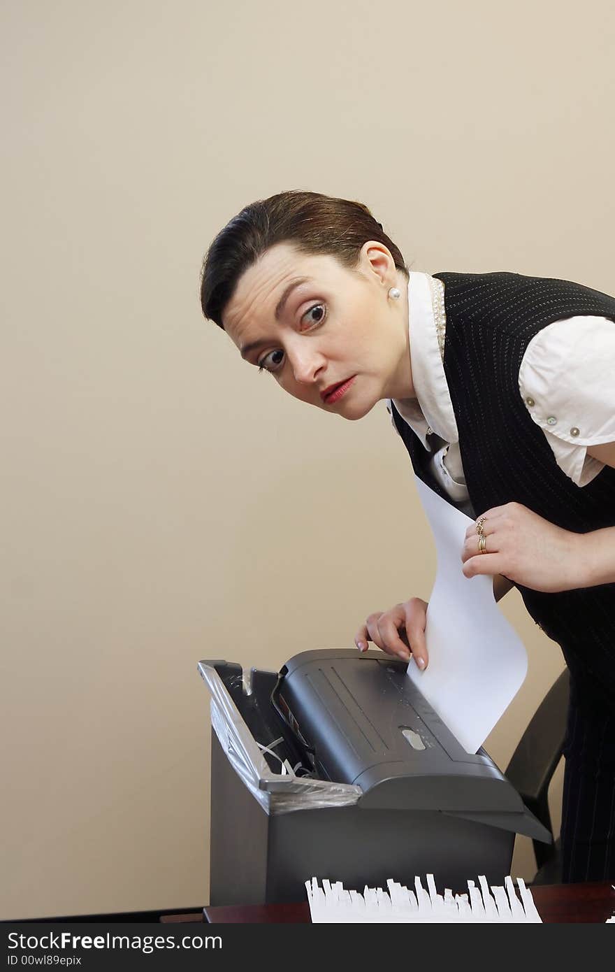 Businesswoman shredding documents at her desk