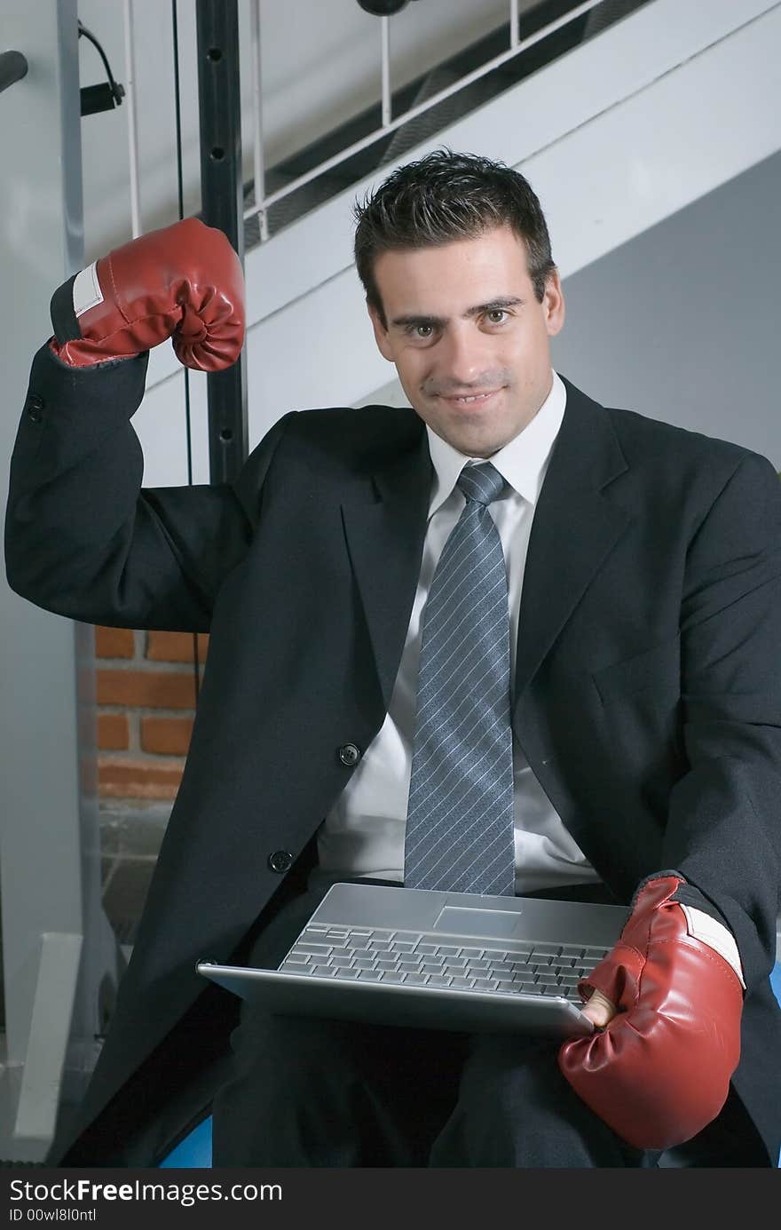 A shot of a businessman, in a suit, wearing a pair of boxing gloves. A shot of a businessman, in a suit, wearing a pair of boxing gloves.