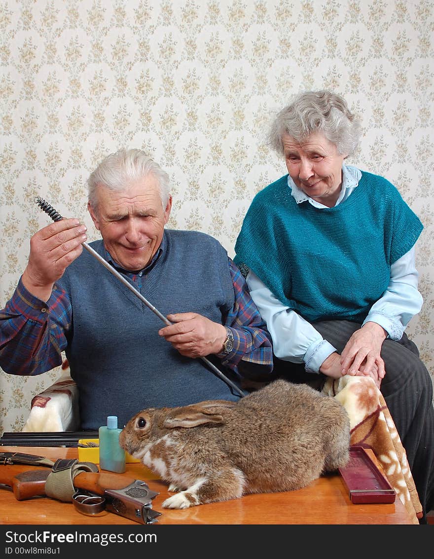 Grandparent and rabbit prepare double-barrelled gun to hunt