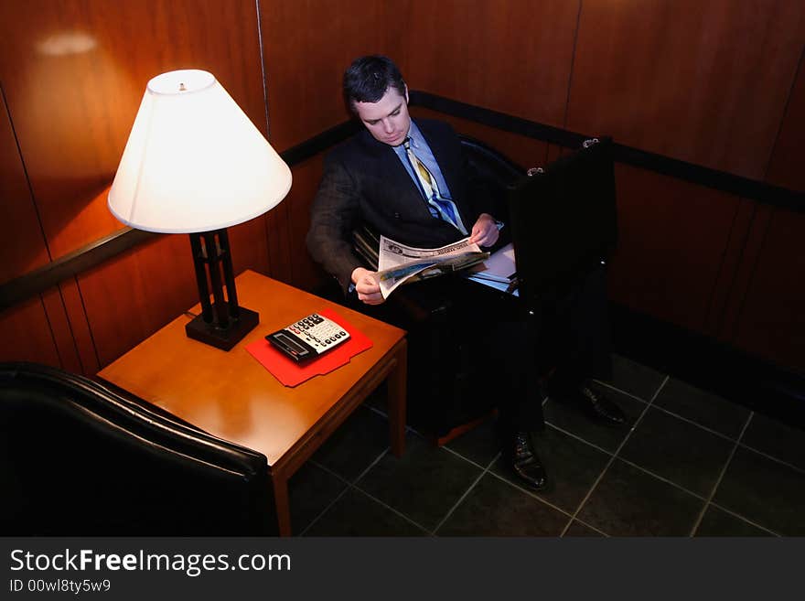 Businessman waiting in an office lobby with his briefcase open. Businessman waiting in an office lobby with his briefcase open