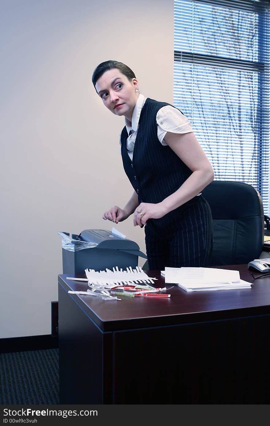 Businesswoman shredding documents at her desk